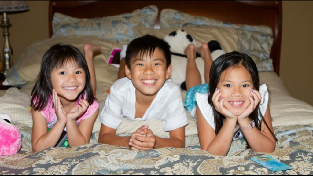 Picture of three children smiling for camera